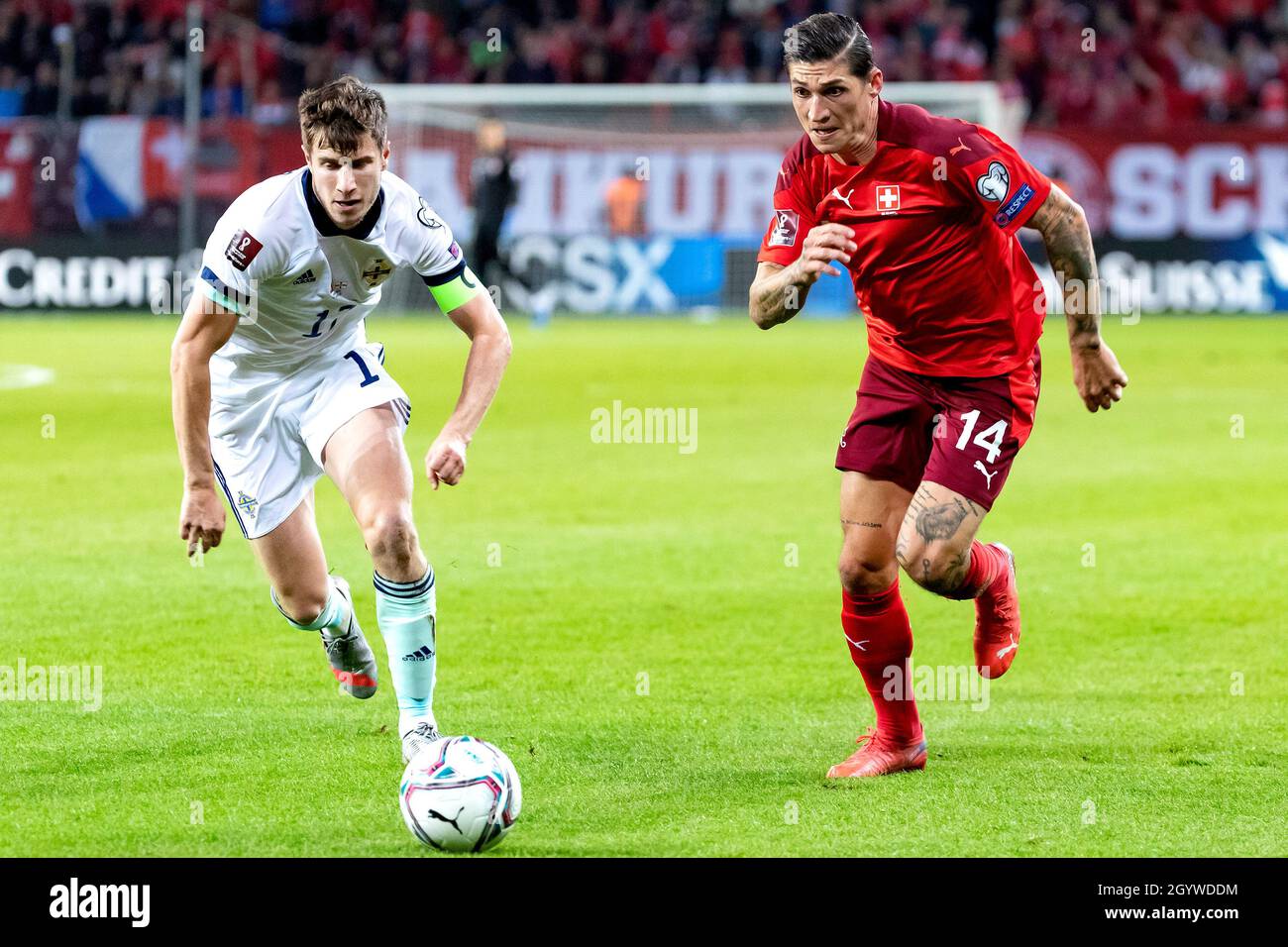 Northern Ireland's Paddy McNair (left) and Switzerland's Steven Zuber battle for the ball during the FIFA World Cup Qualifying match at Stade de Geneve, Switzerland. Picture date: Saturday October 9, 2021. Stock Photo