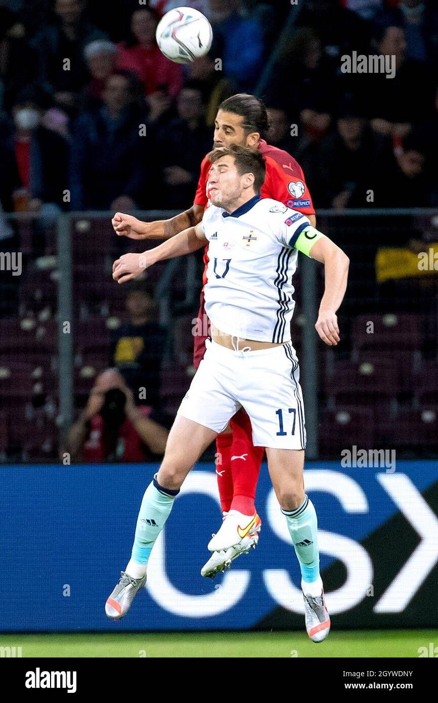 Switzerland's Ricardo Rodriguez (back) and Northern Ireland's Paddy McNair battle for the ball during the FIFA World Cup Qualifying match at Stade de Geneve, Switzerland. Picture date: Saturday October 9, 2021. Stock Photo