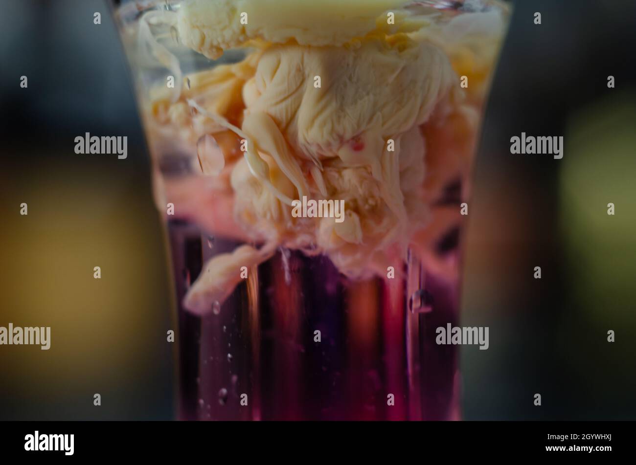 Interesting drink shot based on cream, liqueur and grenadine called Brain Hemorrhage prepared for Halloween party, scary drink Stock Photo