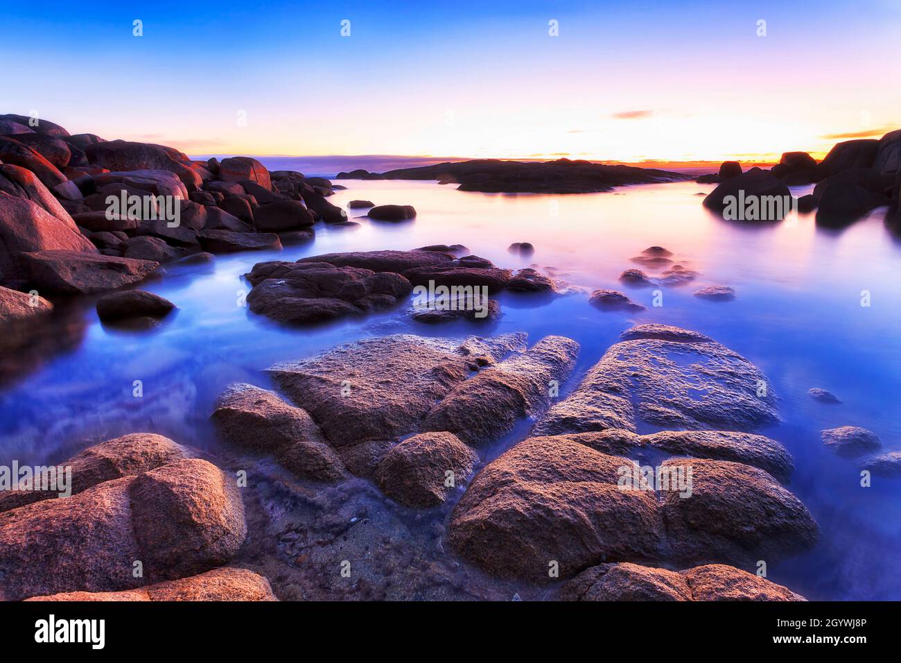 Dawn in Bay of Fire Binalong bay granite scenic East coast of Tasmania - seascape with granite boulders. Stock Photo