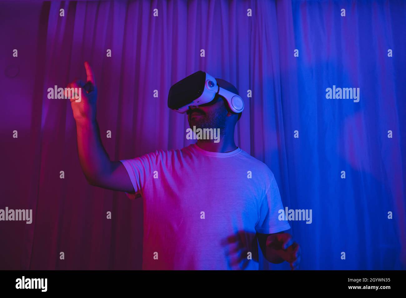 young man using vr glasses in his room. Stock Photo