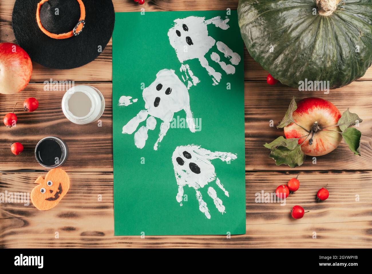 Step-by-step Halloween tutorial ghosts child's handprint. Step 9: Finished drawing of ghosts made with children's handprints. Top view Stock Photo
