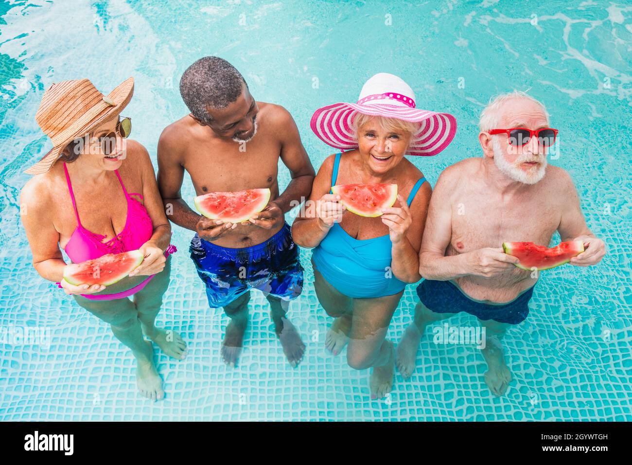 Senior Pool Fun Happy seniors having party in the swimming pool - Elderly friends at a ...