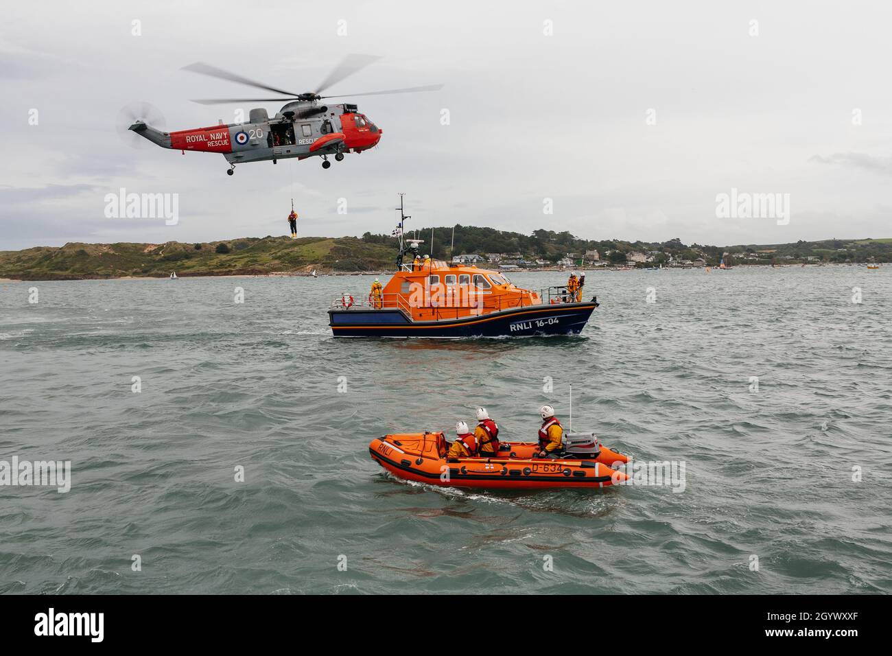 The RNLI crew in Padstow rehearsing a sea rescue with the Royal Navy air and sea rescue helicopter team and transferring the casualty to the lifeboat. Stock Photo