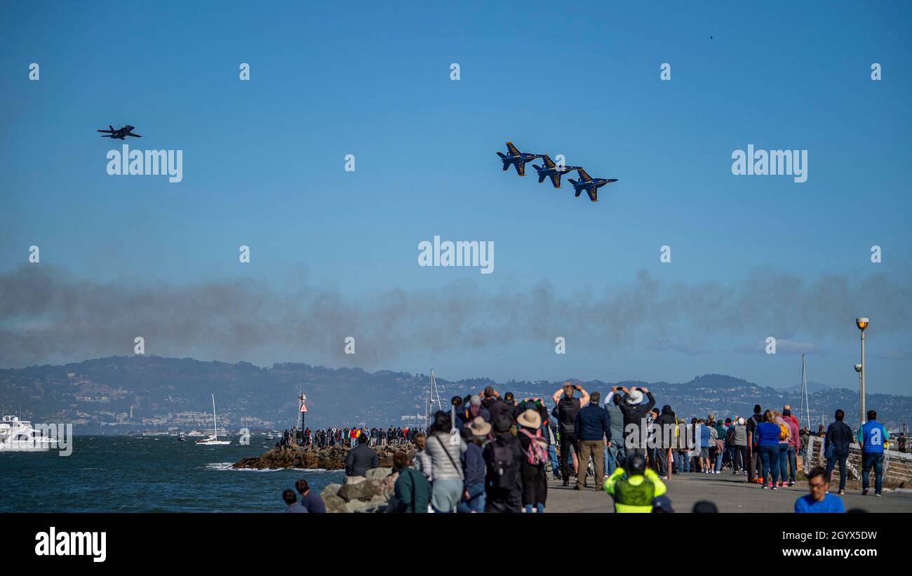 211008-N-SS350-3226 SAN FRANCISCO (Oct. 8, 2021) Onlookers watch the Navy Flight Demonstration Squadron, the “Blue Angels,” perform an air show during San Francisco Fleet Week (SFFW) 2021. SFFW is an opportunity for the American public to meet their Navy, Marine Corps and Coast Guard teams and experience America's sea services. During fleet week, service members participate in various community service events, showcase capabilities and equipment to the community, and enjoy the hospitality of the city and its surrounding areas. (U.S. Navy photo by Mass Communication Specialist 3rd Class Jason W Stock Photo