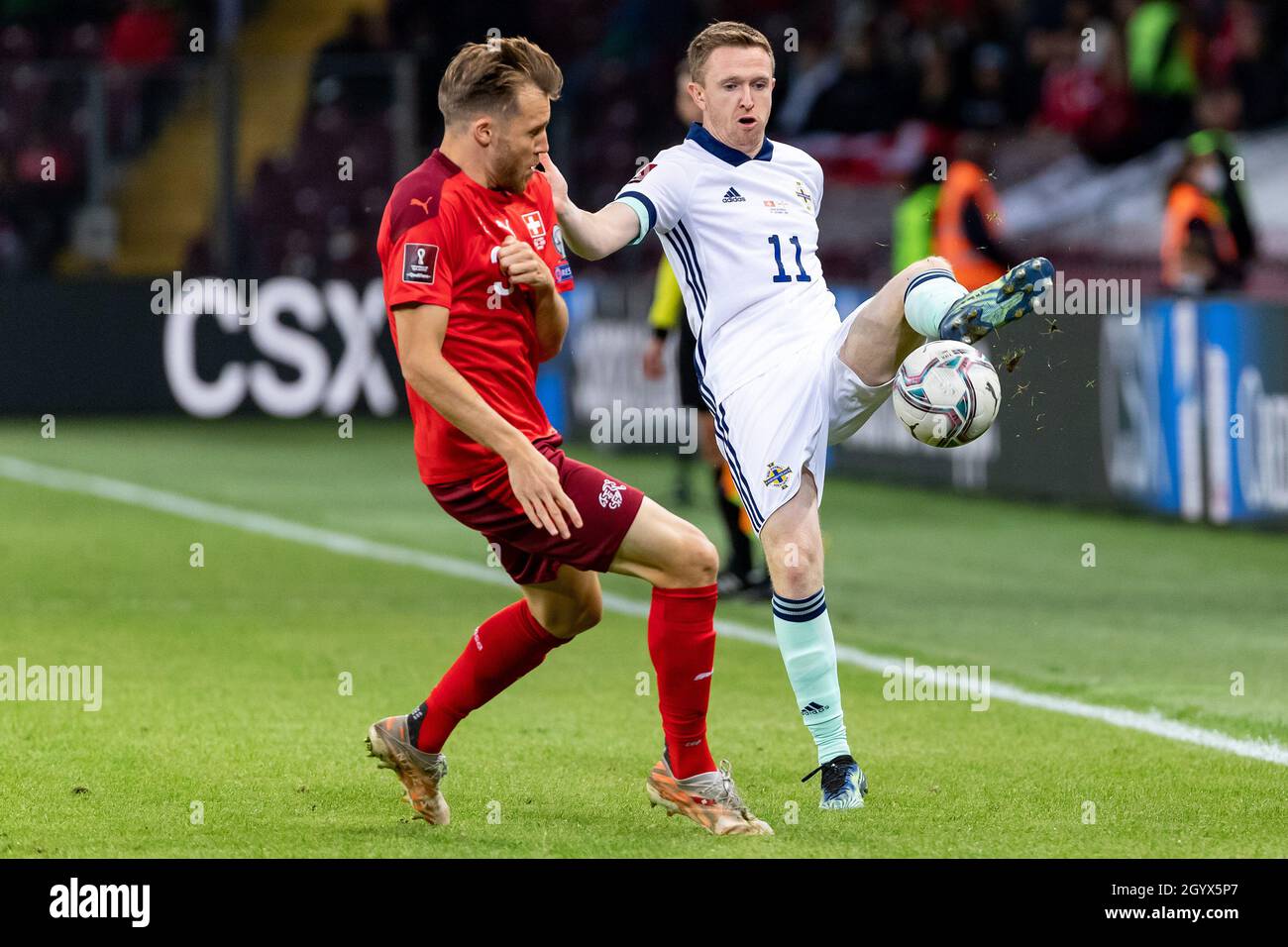Switzerland's Silvan Widmer (left) and Northern Ireland's Shane Ferguson battle for the ball during the FIFA World Cup Qualifying match at Stade de Geneve, Switzerland. Picture date: Saturday October 9, 2021. Stock Photo