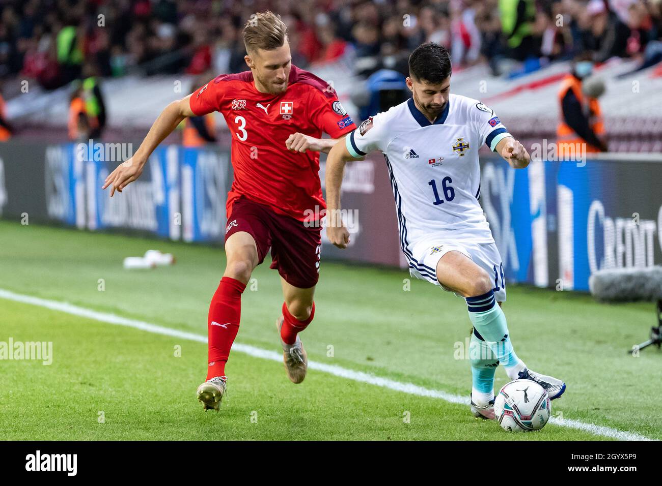 Switzerland's Silvan Widmer (left) and Northern Ireland's Jordan Jones battle for the ball during the FIFA World Cup Qualifying match at Stade de Geneve, Switzerland. Picture date: Saturday October 9, 2021. Stock Photo