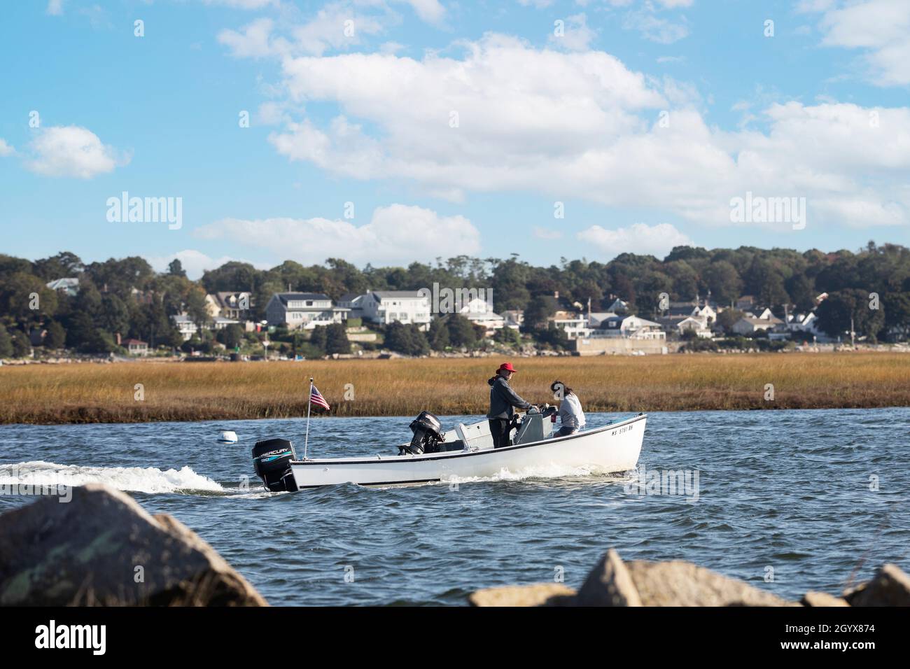 A motor boat passes through the James River Salt Marsh in Gloucester, Massachusetts, USA. Stock Photo