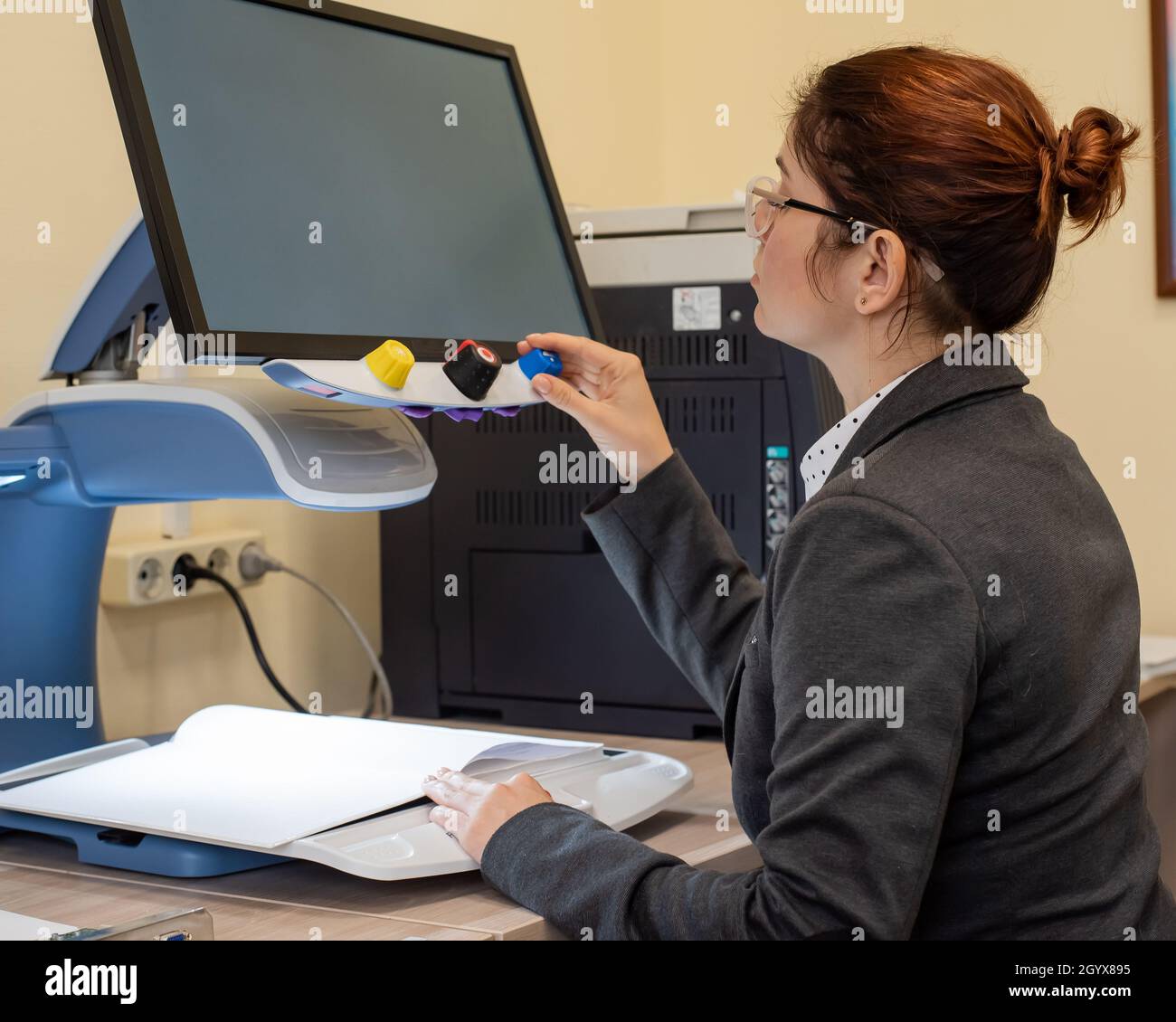A visually impaired woman uses special reading equipment Stock Photo