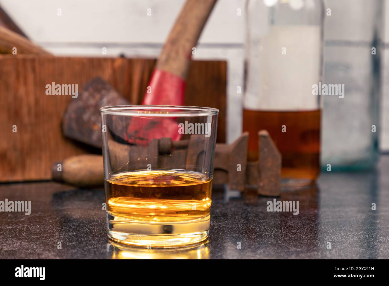 Glass of Bourbon Whiskey, Neat, in front of vintage tools Stock Photo