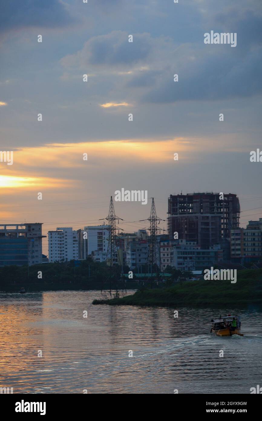 Lake view of Dhaka city with skyline buildings in the evening. Sunlight reflected in the lake water. Stock Photo