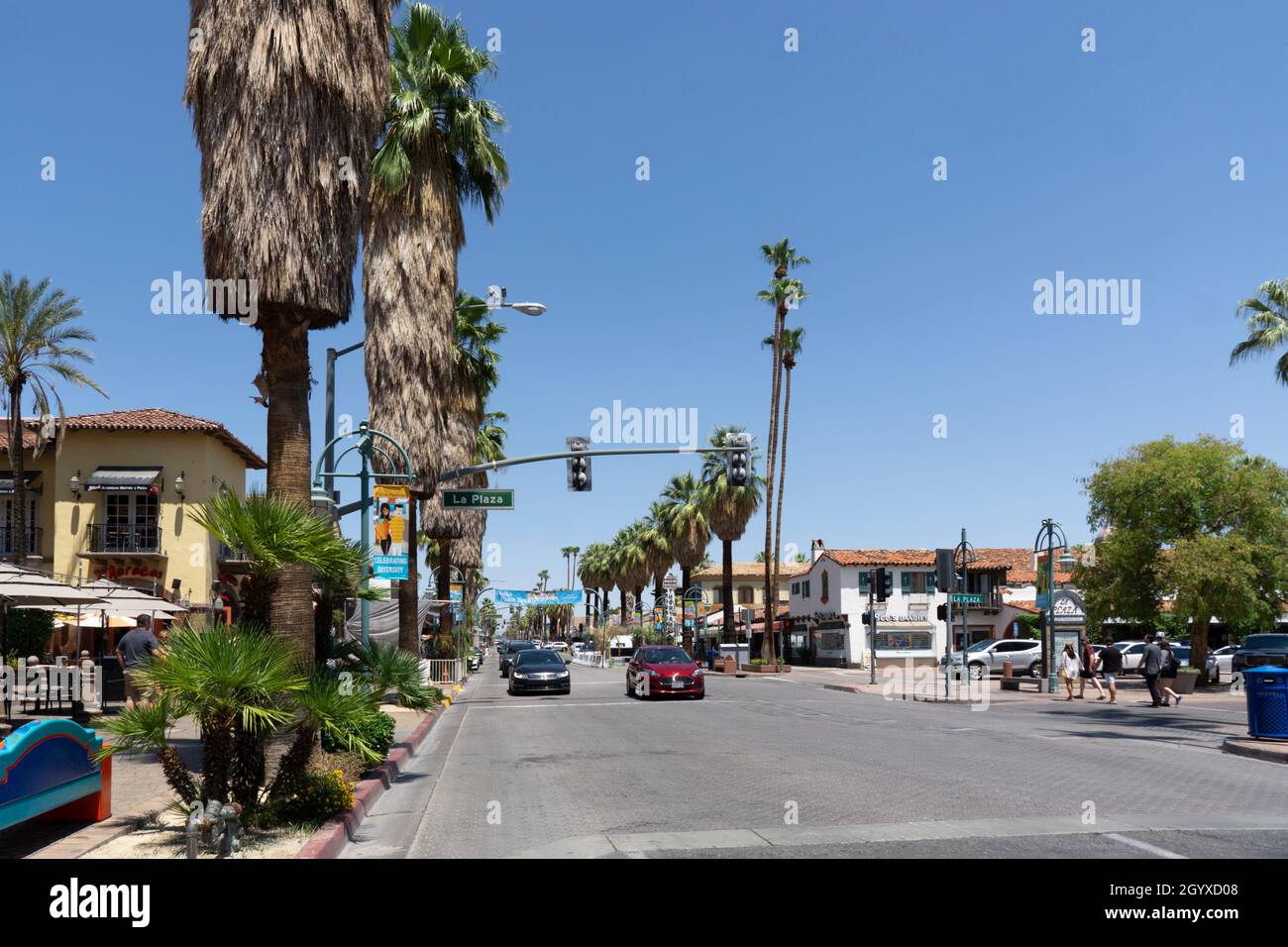 Palm Springs, California, USA - August 8, 2021: Street with cars approaching and stores or restaurants open for tourists. Sunny day in Palm Springs wi Stock Photo