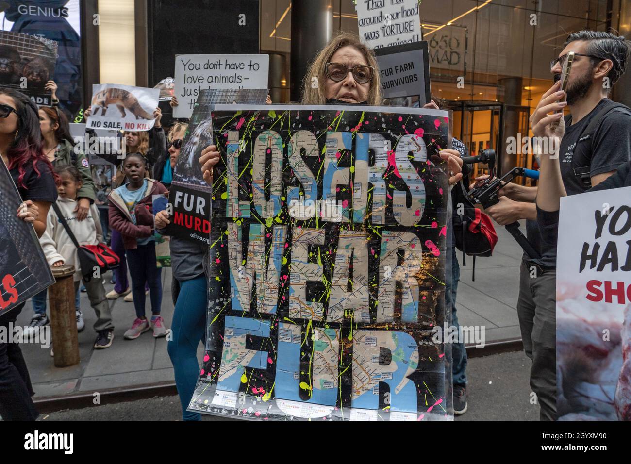 NEW YORK, NY - OCTOBER 9: Animal rights activist holds a sign reading  "losers wear fur" during an Anti-Fur March in front of the Moncler store on  Madison Avenue on October 9,