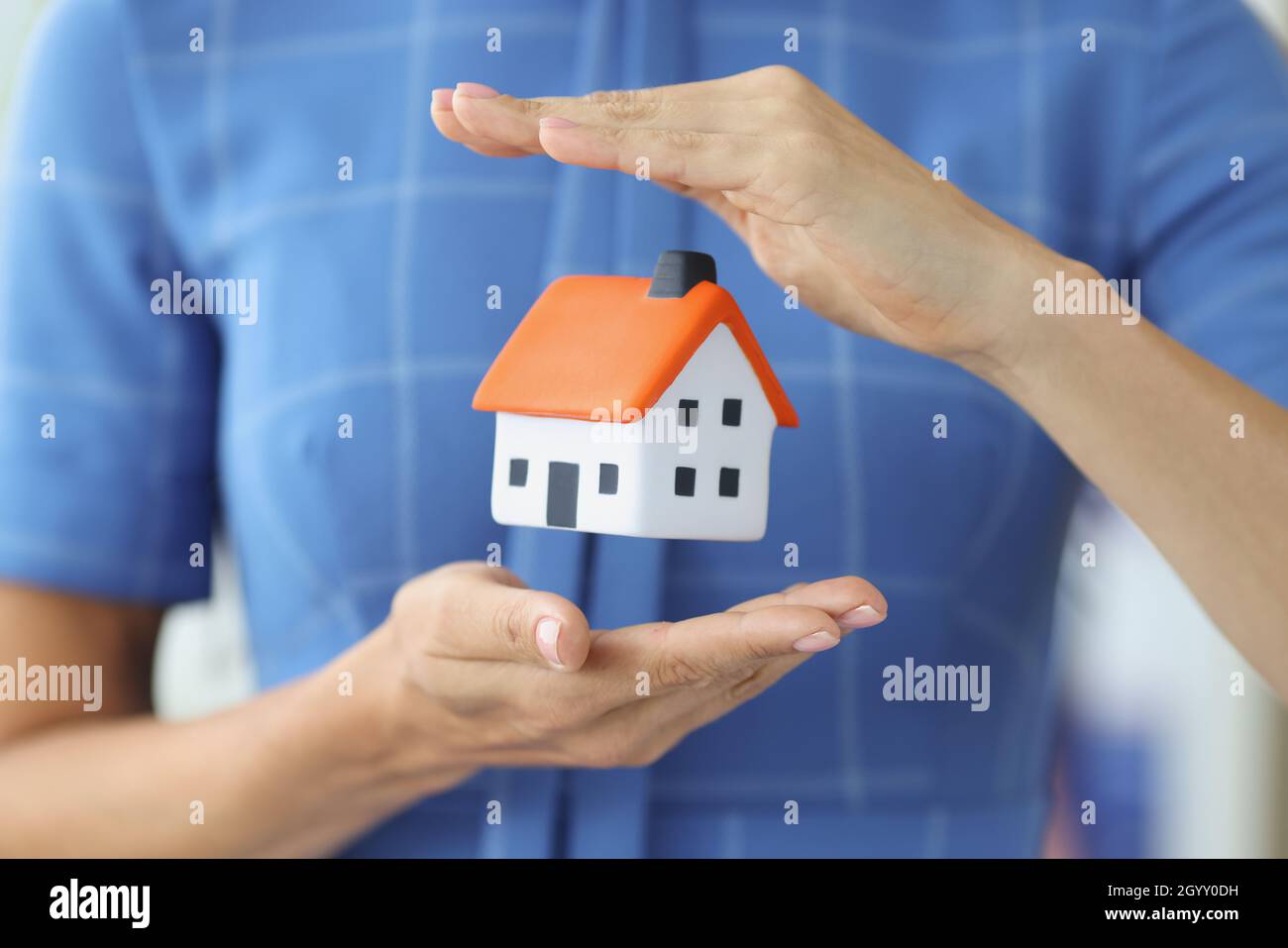 Small house in female hands of air. Stock Photo
