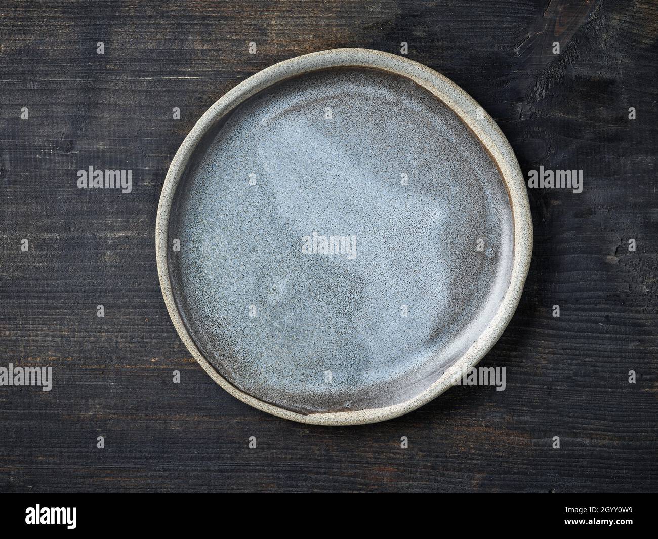 empty grey ceramic plate on dark wooden kitchen table, top view Stock Photo