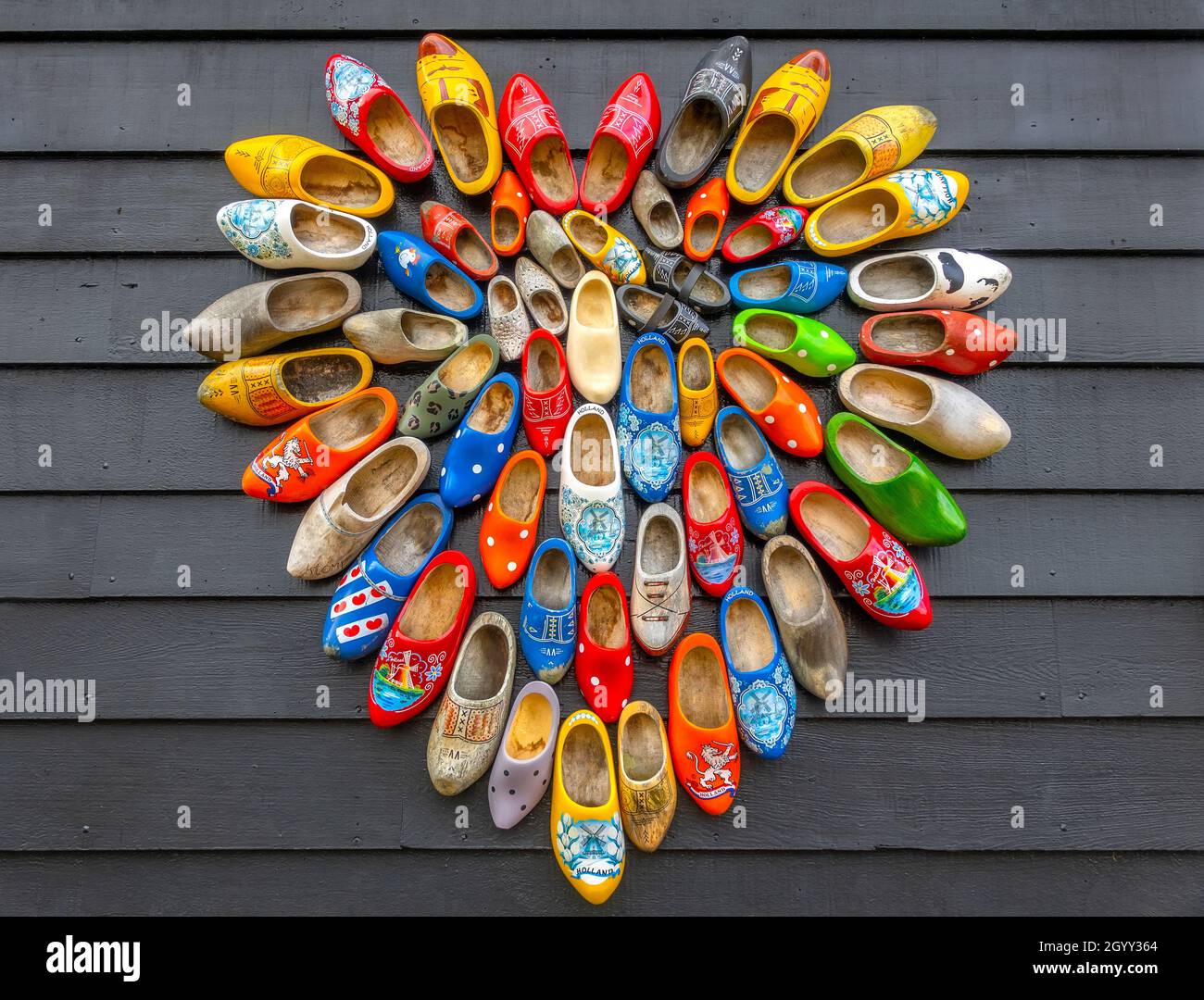 Netherlands. Rough background from gray boards. Many national Dutch Klomp shoes are laid out in the shape of a heart Stock Photo