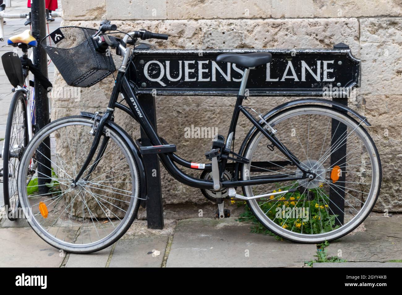 Bicycle locked to the street sign for Queen's Lane, Oxford, England, UK Stock Photo