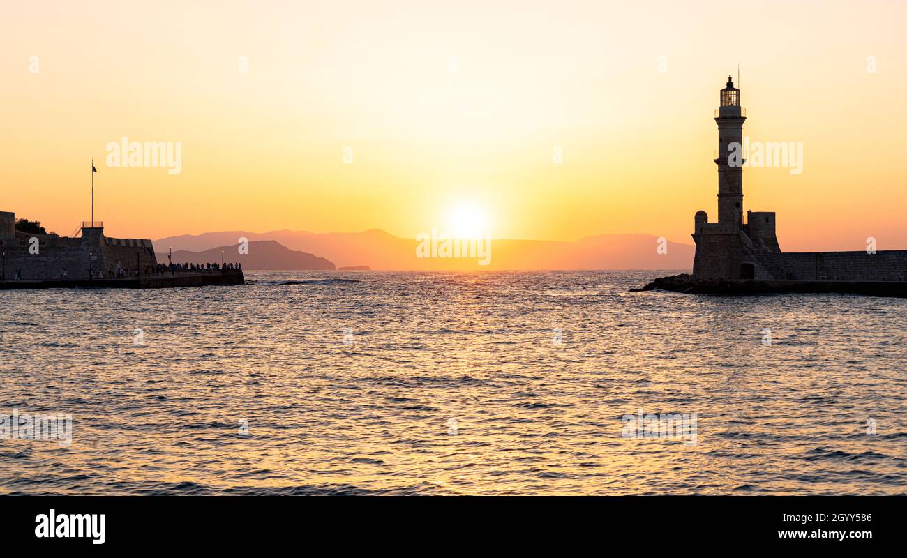 Sunset over lighthouse and ancient fortress of Chania old town, Crete, Greece Stock Photo