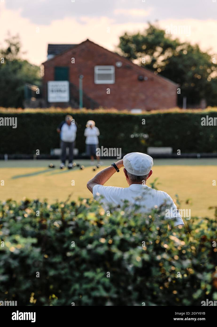 Lawn bowls players / bowlers in whites at a summer evening tournament  game in rural England Britain UK - British summer bowling green club Stock Photo