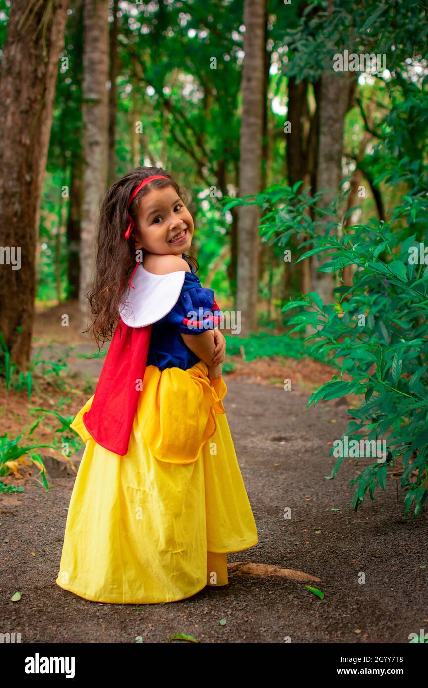 A cute little Hispanic girl wearing a Snow White dress as her Halloween