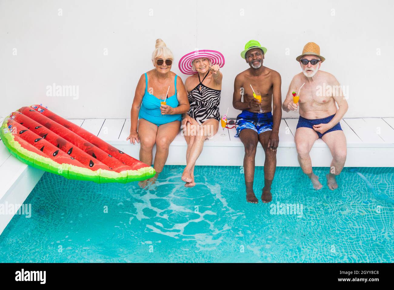 Senior Pool Fun Happy seniors having party in the swimming pool - Elderly friends at a ...
