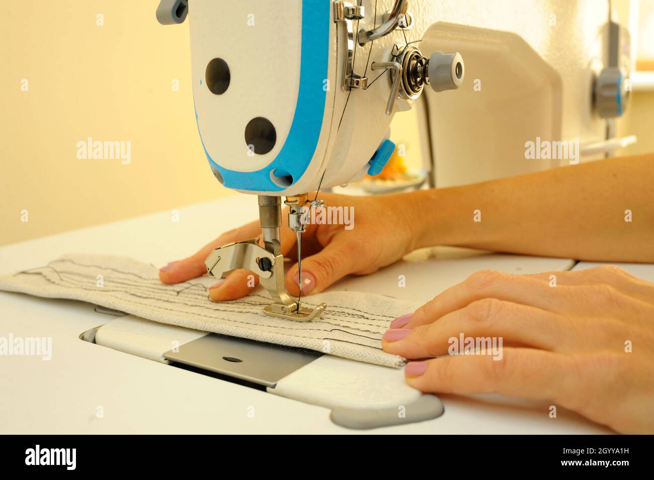Seamstress hands sew on a sewing machine. Parts of sewing machine