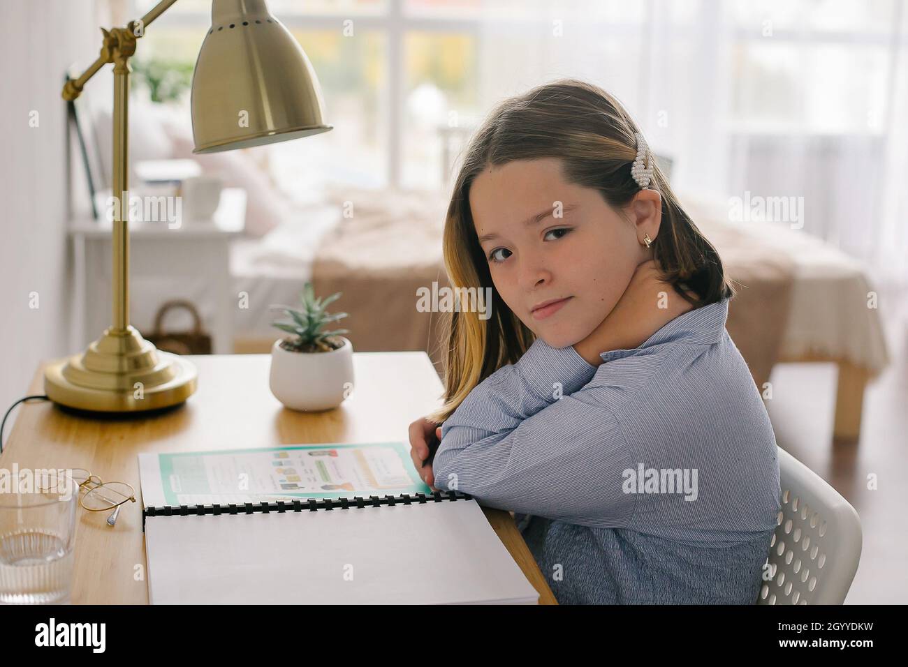 Portrait school girl siting at desk doing homework. Home schooling, distance education conceptmentary school and home schooling, Distance Education co Stock Photo