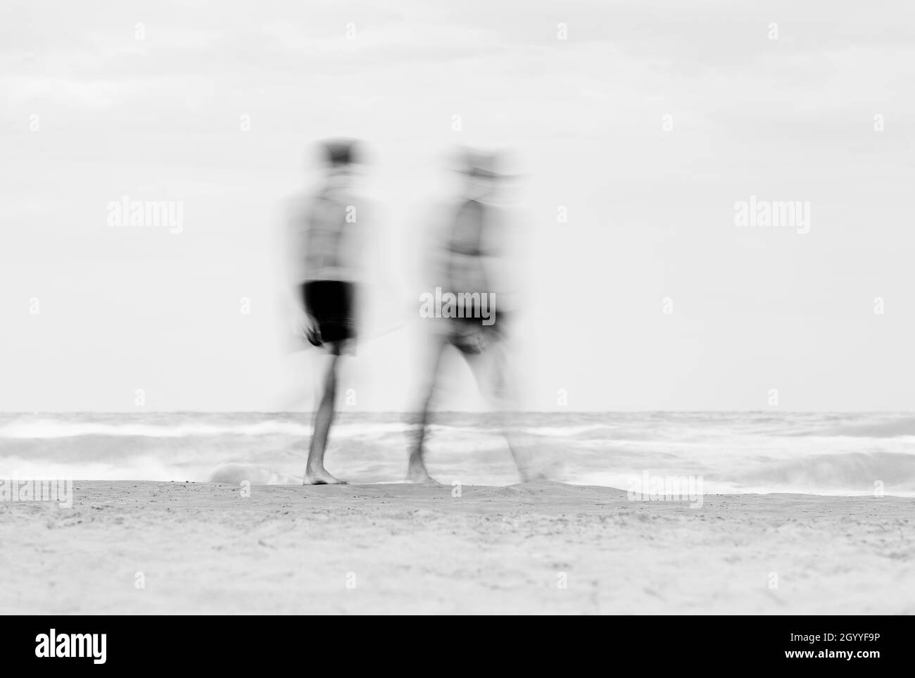 Bathers stroll on the beach Stock Photo