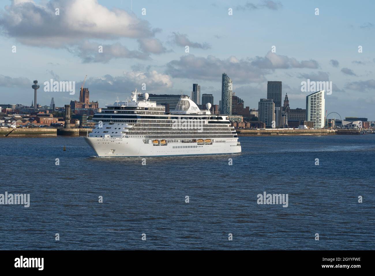 The Regent Seven Seas cruise ship Seven Seas Splendor leaves Liverpool with the city skyline in the background Stock Photo
