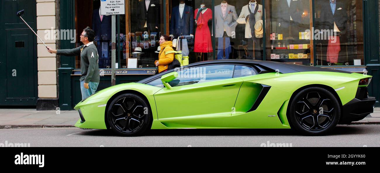 Flash lime green sports car (Ferrari?) and an ardent admirer, in Cambridge UK Stock Photo