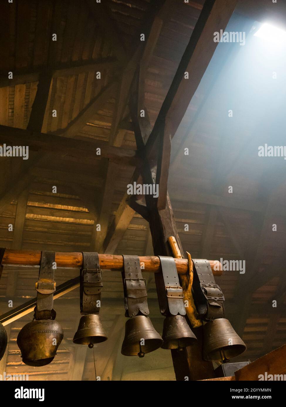 Traditional cowbells are hanging on the attic of a an alpine dairy in Switzerland Stock Photo