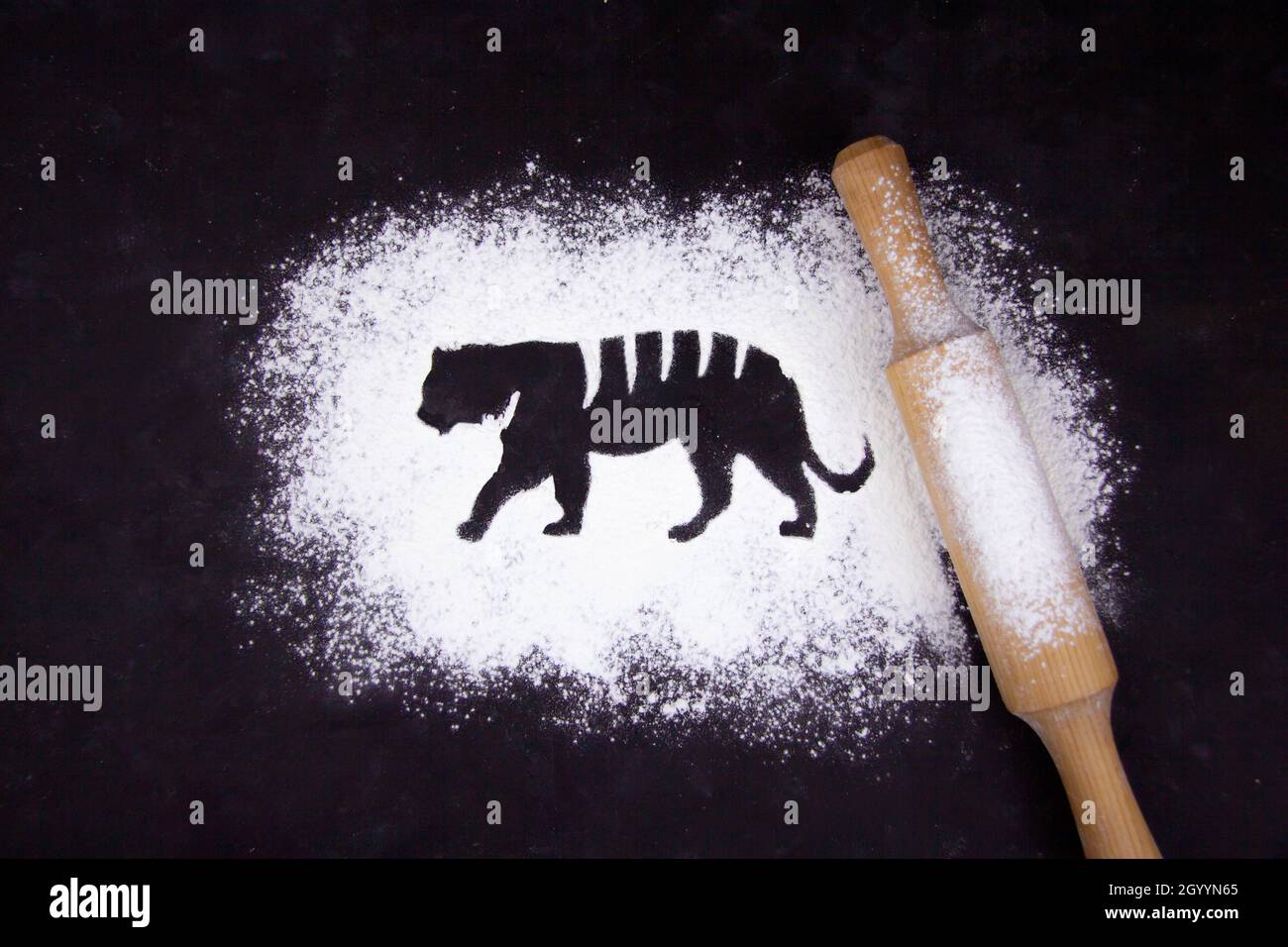 Flour on a dark background and silhouette of a tiger, new year 2022, silhouette and symbol of the new year, Chinese new year New Year Christmas cookin Stock Photo