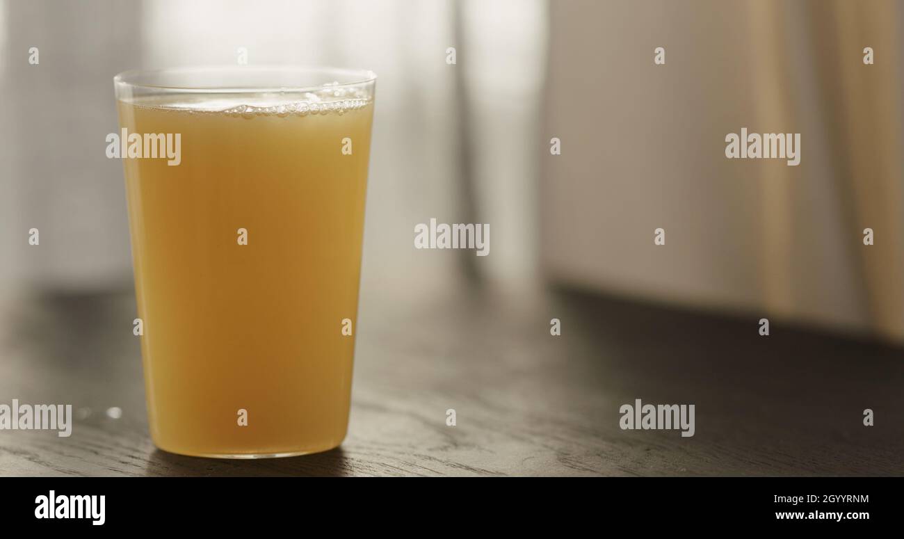 orange juice with sparkling water in tumbler glass on black wood table with copy space, wide photo Stock Photo