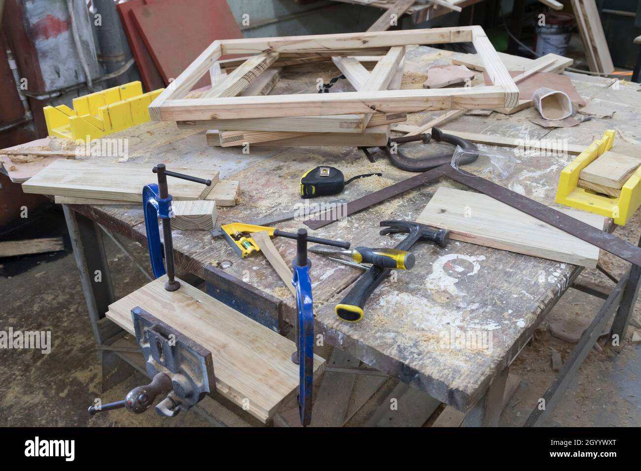 carpenter's workbench cluttered with workpieces and tools Stock Photo