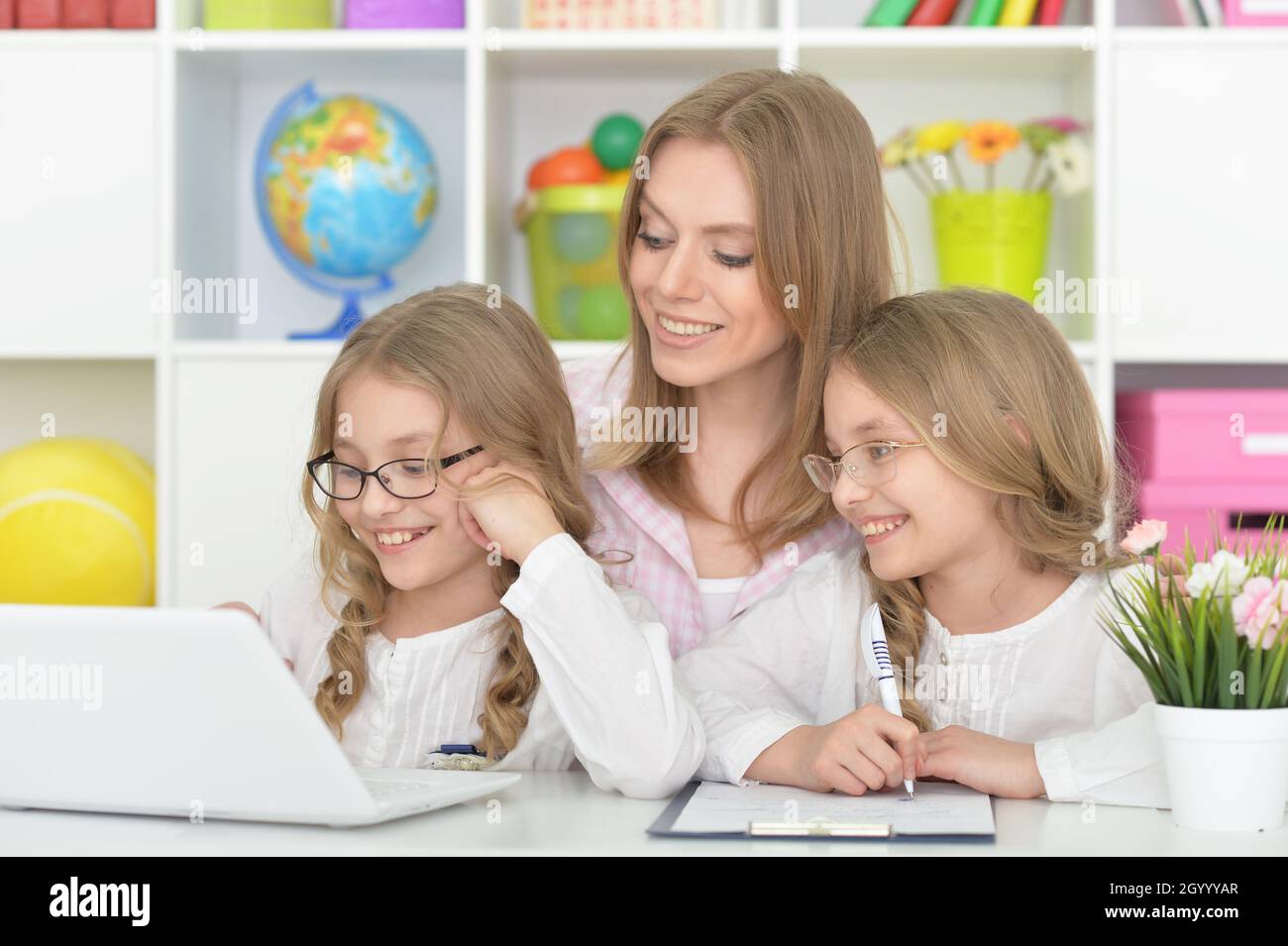 beautiful smiling girls using laptop with mother Stock Photo - Alamy