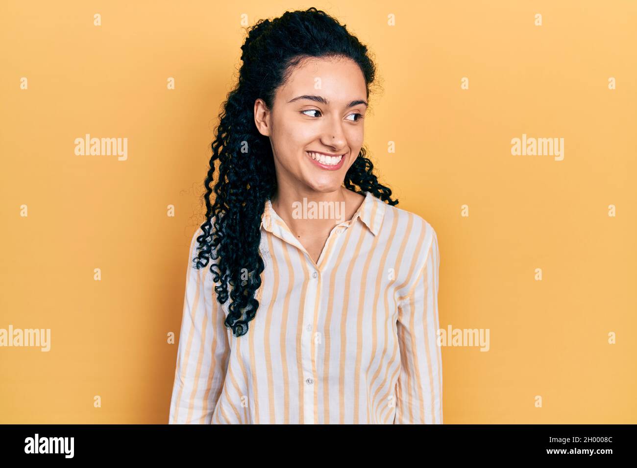 Hispanic Poses Young hispanic woman with curly hair wearing casual striped shirt ...