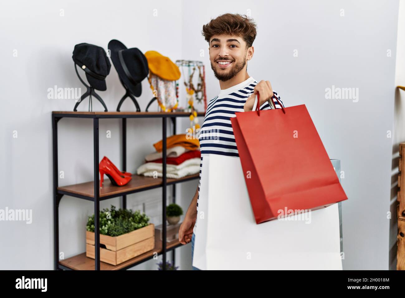 Young arab man customer smiling confident shopping at clothing store ...