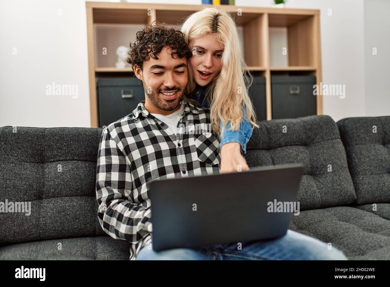 Young couple using laptop sitting on the sofa at home Stock Photo - Alamy