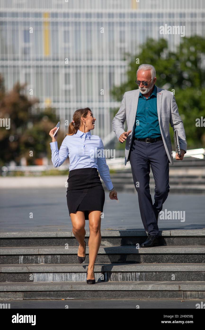 Business man and woman walking in rush on city square, running on ...