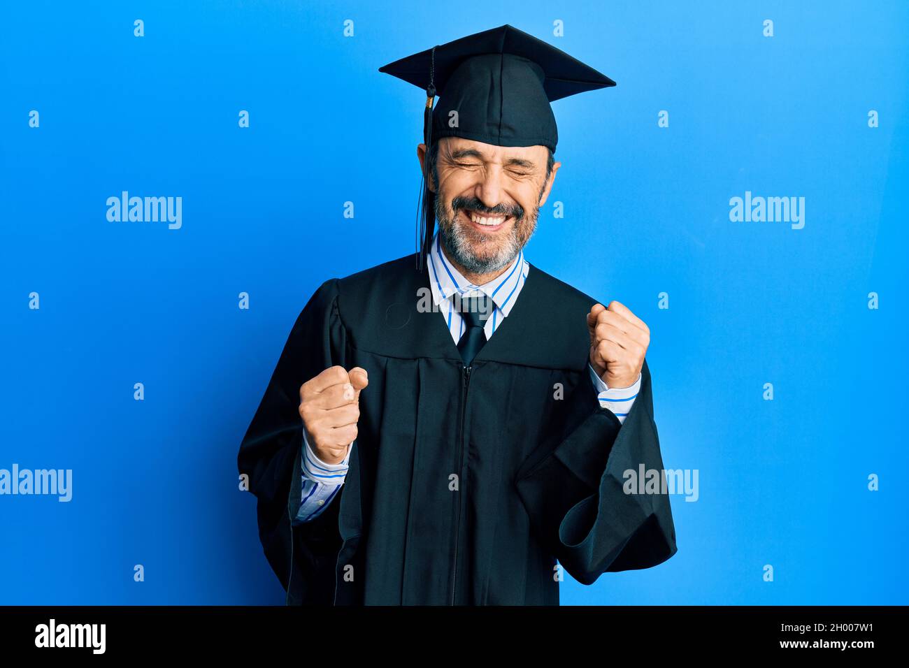 Middle age hispanic man wearing graduation cap and ceremony robe ...