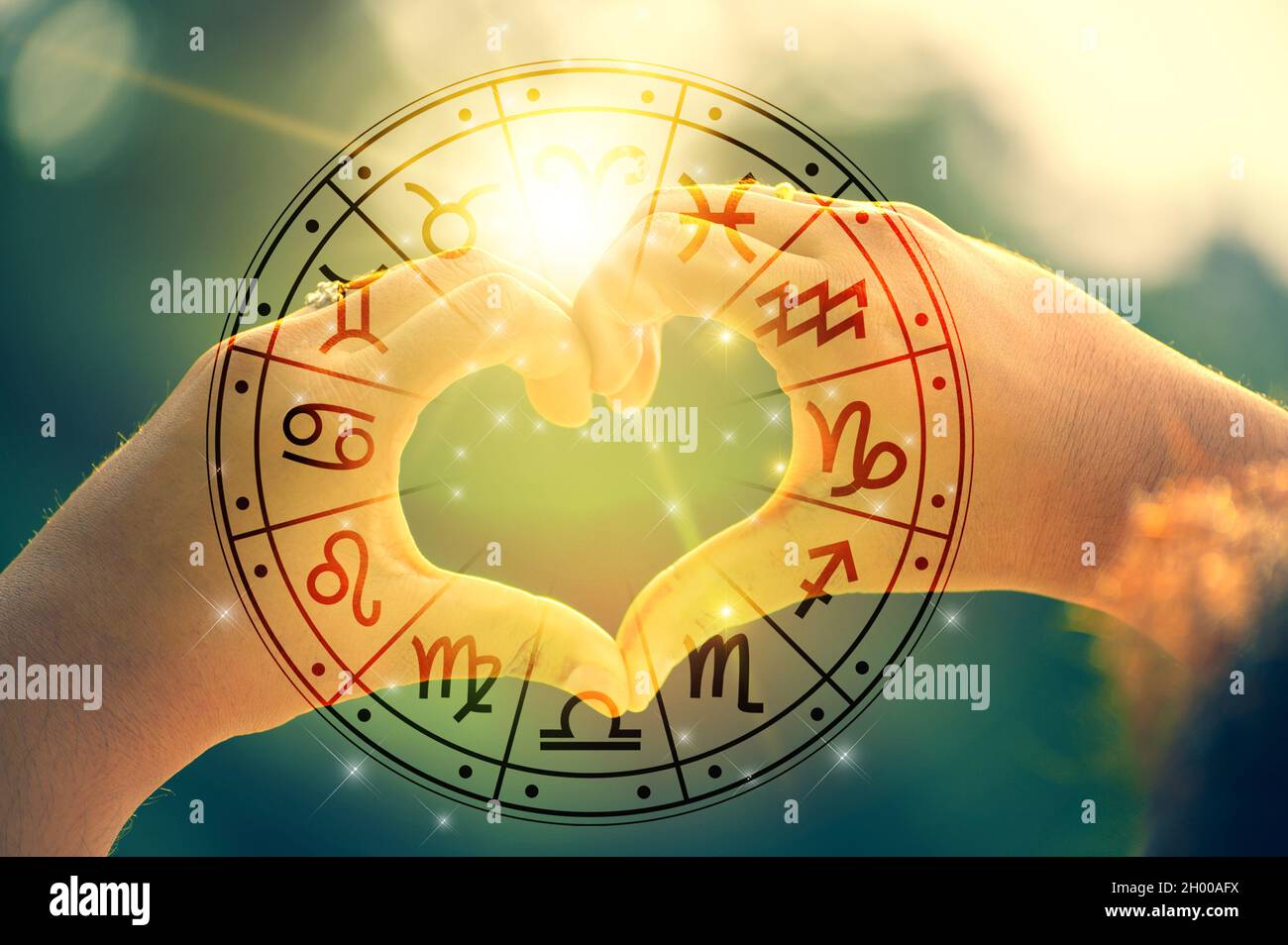 The hands of women and men are the heart shape with the sun light passing through the hands have astrological symbols Stock Photo