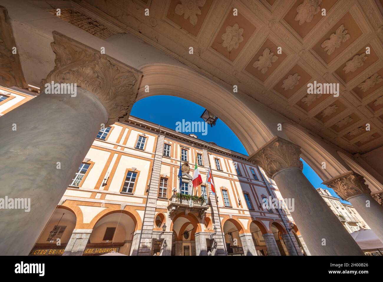 Cuneo, Piedmont, Italy - October 6, 2021: the town hall seen from the arches of the historic artistic arcades (Portici di Cuneo) in Via Roma Stock Photo