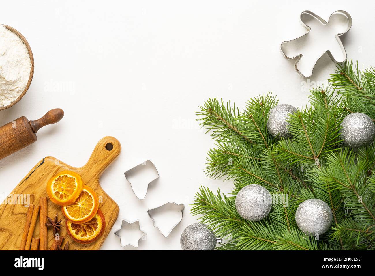 Green branches of the Christmas tree, oranges, ingredients for ginger cookies on a white background, merry Christmas and New Year. Top view Stock Photo