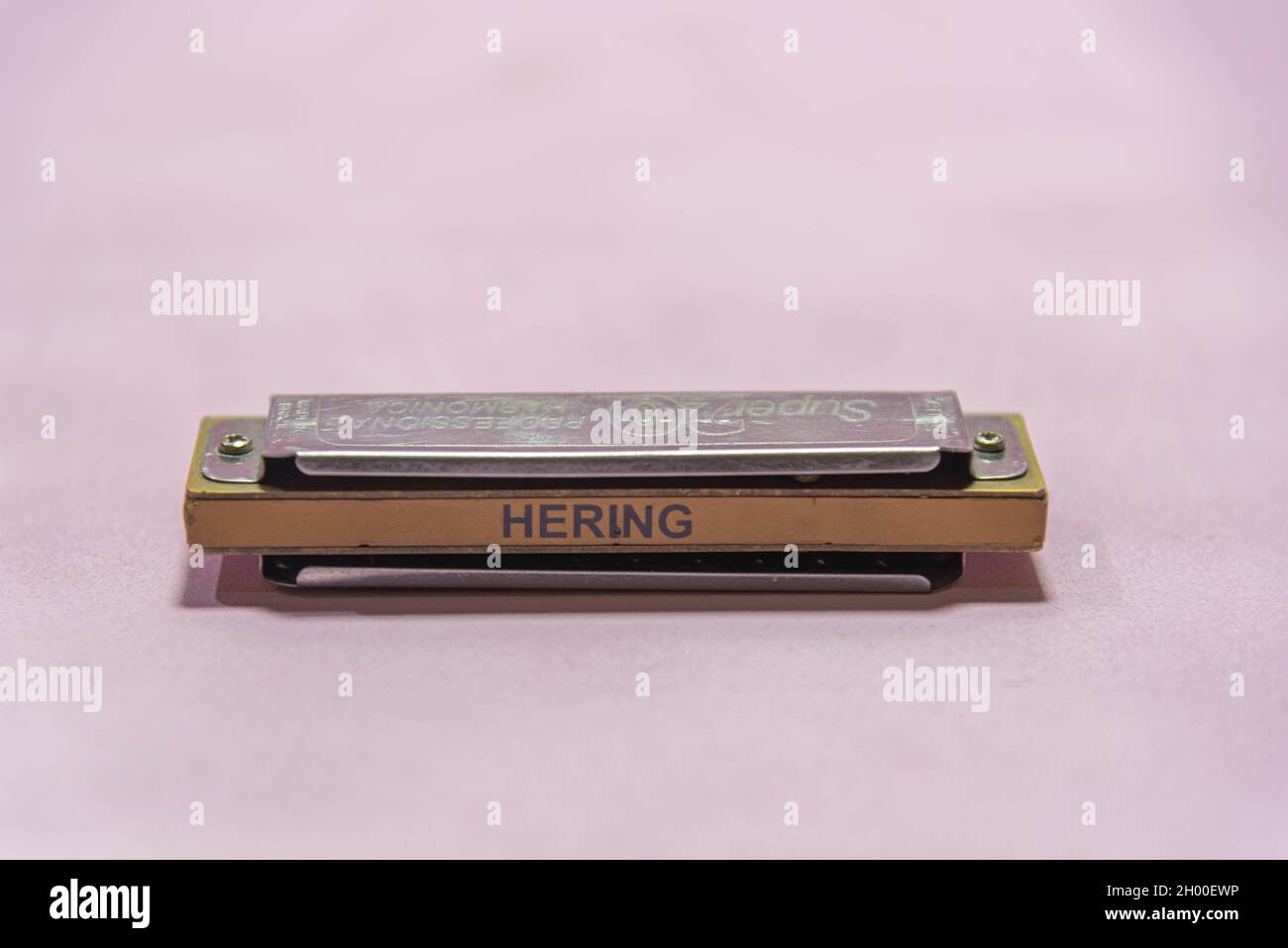Harmonica. Musical instrument. Pink background. Wind instrument