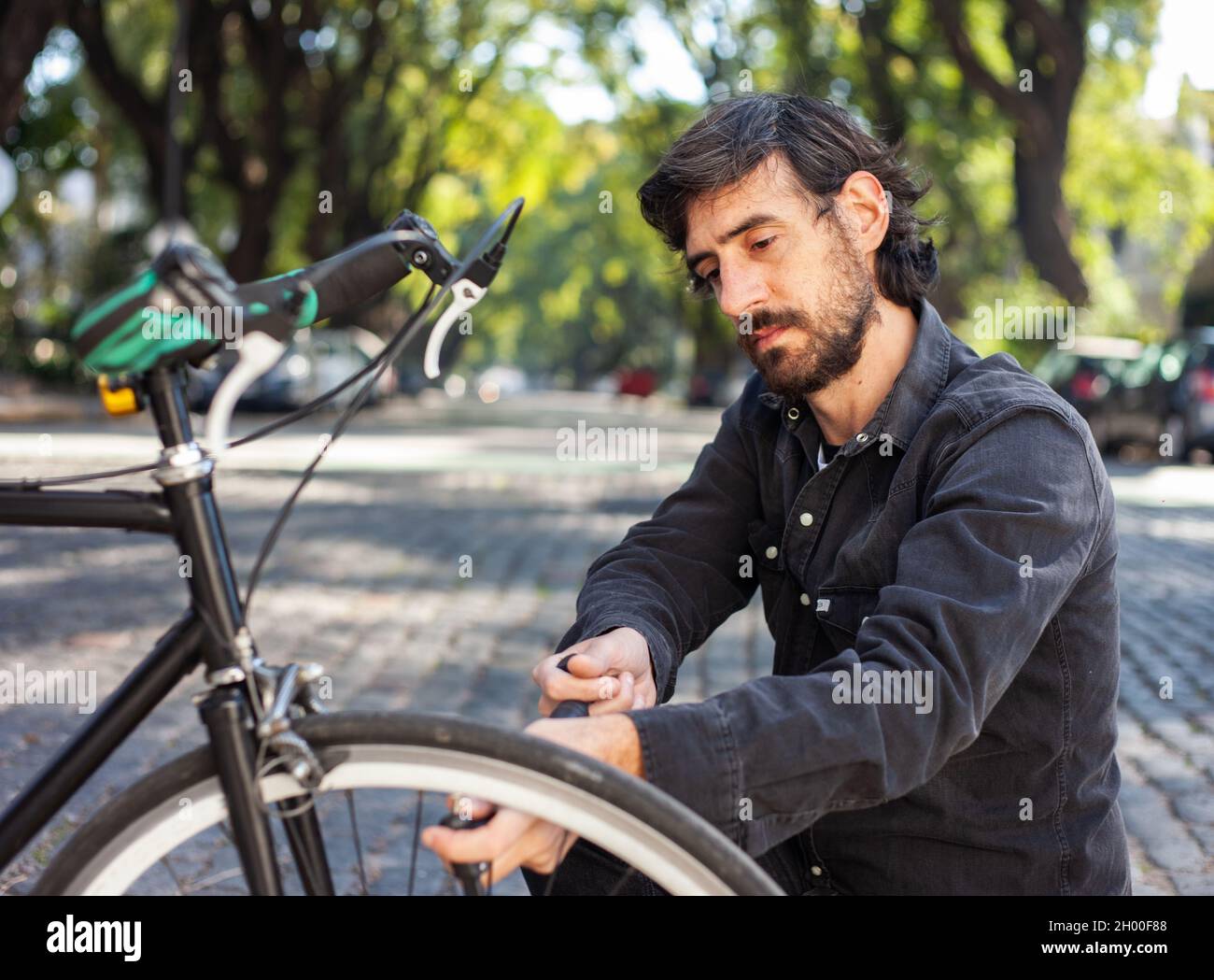 A Caucasian male fixing a broken bike Stock Photo Alamy