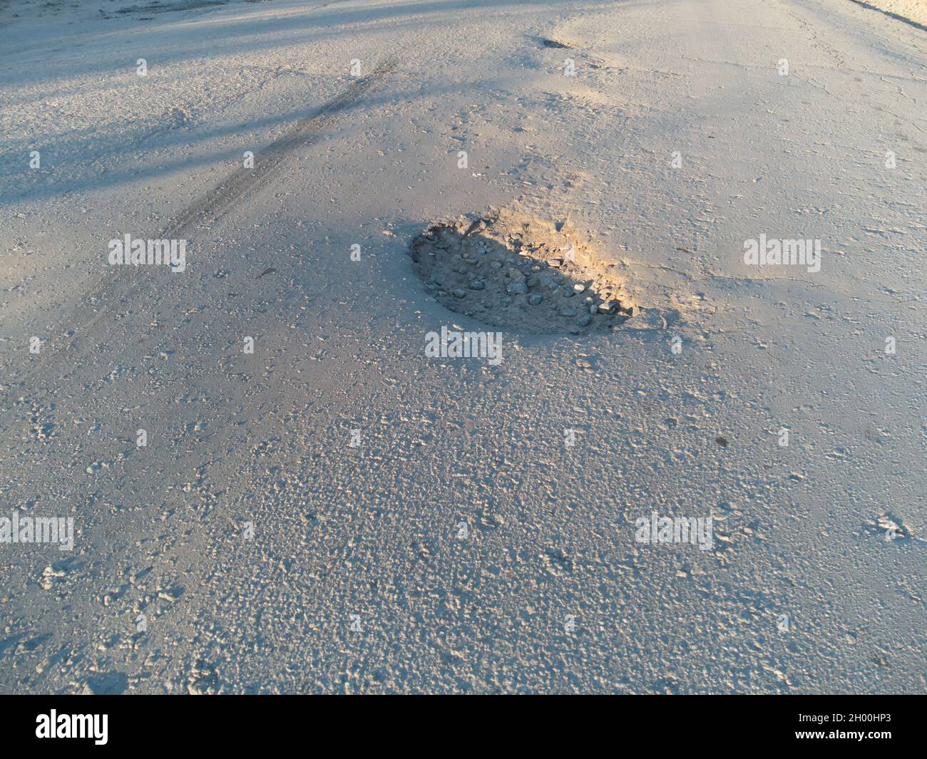 Pothole on the asphalt. A pit formed on the road surface. Stock Photo