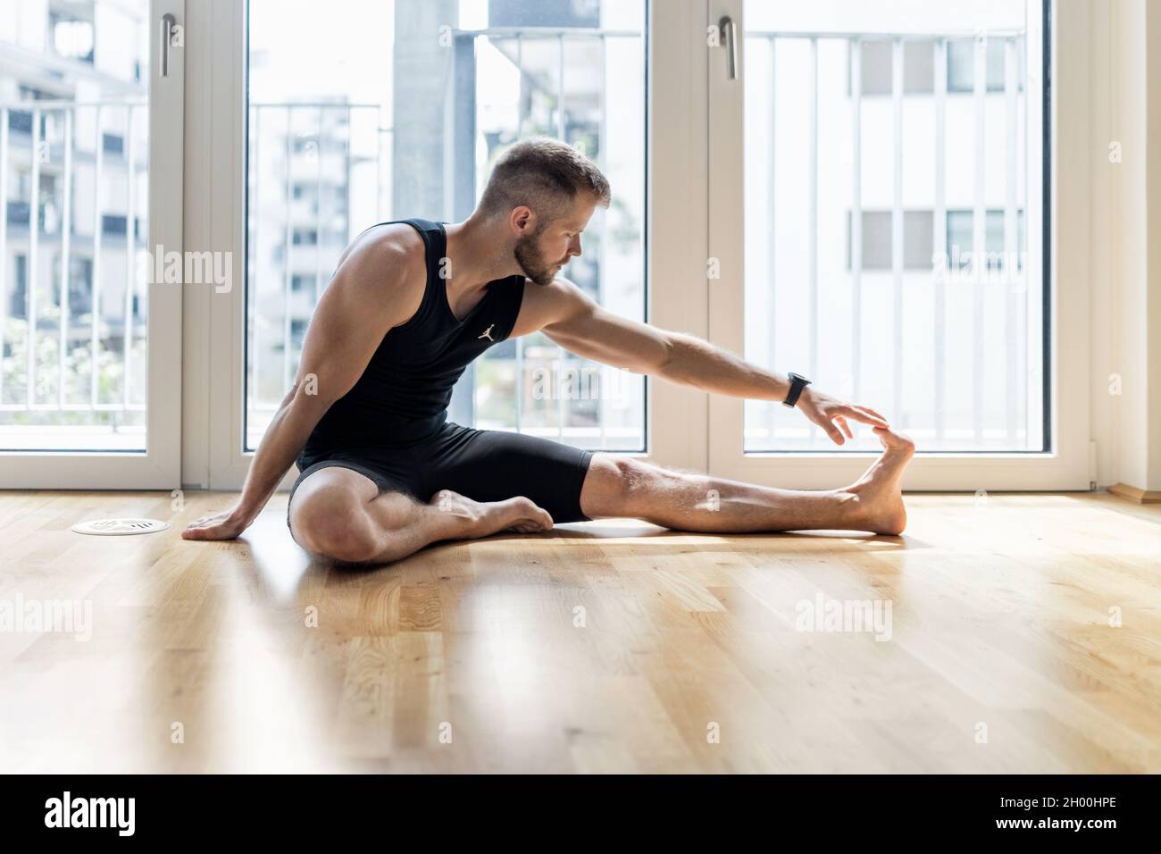 Young handsome man practicing yoga at home Stock Photo