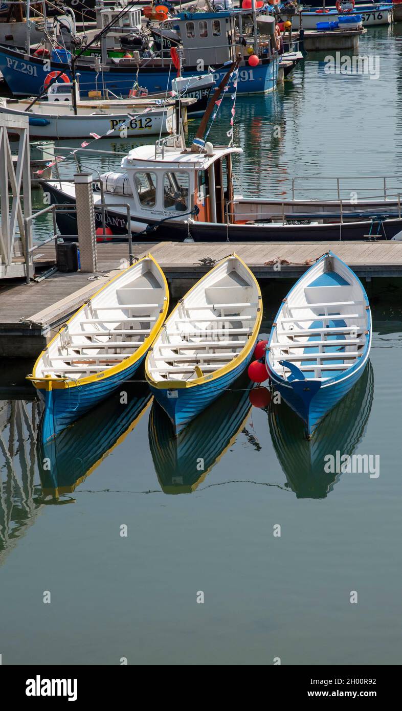 Newlyn Harbour, Cornwall, England, UK. 2021.  Three pilot gig boats on  a jetty in Newlynn Harbour. Stock Photo