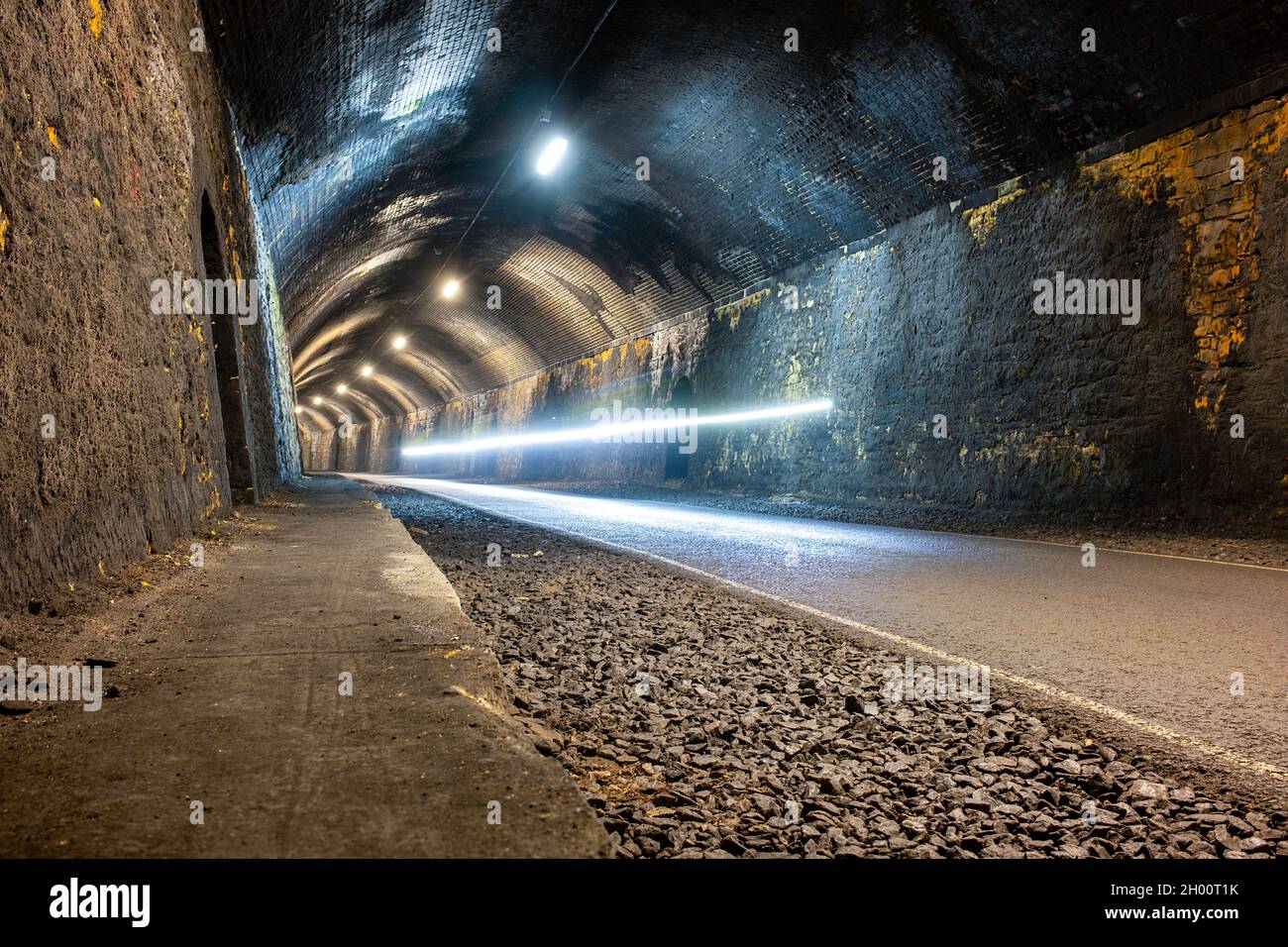 Monsal trail cycle path through old lit train tunnels Derbyshire UK Stock Photo