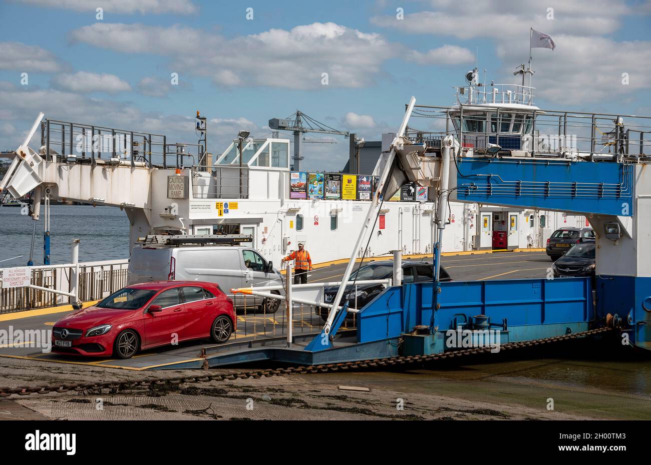 Torpoint, Cornwall, England, UK. 2021. Red car on the ramp unloading from a roll on rool off chain ferry which crosses the River Tamar between Plymout Stock Photo